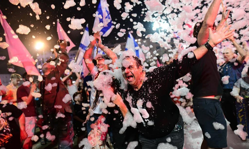 People celebrate after Israel's parliament approved a new coalition government on Rabin Square in Tel Aviv, on June 13, 2021. Naftali Bennett, leader of the right-wing Yamina (United Right) party, was sworn in as new Israeli prime minister on Sunday night, sending Benjamin Netanyahu to the opposition after a record 12-year rule.(Photo: Xinhua)