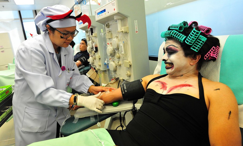 A man dressed in a ghost costume for Halloween donates blood at the Thai Red Cross in Bangkok, Thailand, Oct. 31, 2018. (Photo: Xinhua)