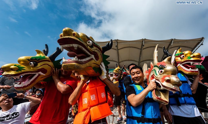 Participants carry the dragon boat heads to the river before a dragon boat race to celebrate the Dragon Boat Festival in Zigui County, central China's Hubei Province, June 14, 2021. China celebrated the Dragon Boat Festival on Monday to commemorate Qu Yuan, a patriotic poet from the Warring States Period (475-221 BC) believed to have been born in Zigui County.(Photo: Xinhua)
