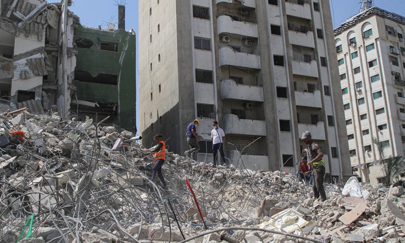 Palestinian workers remove the rubble of a building destroyed by Israeli airstrikes in Gaza City, on June 13, 2021.(Photo: Xinhua)