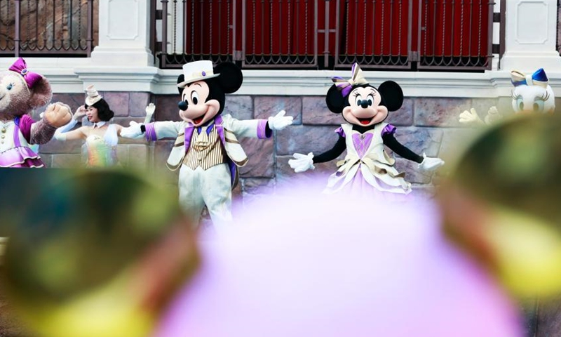 A visitor interacts with Mickey and Minnie at Shanghai Disney Resort, June 16, 2021. (Photo/ Tang Yanjun)
