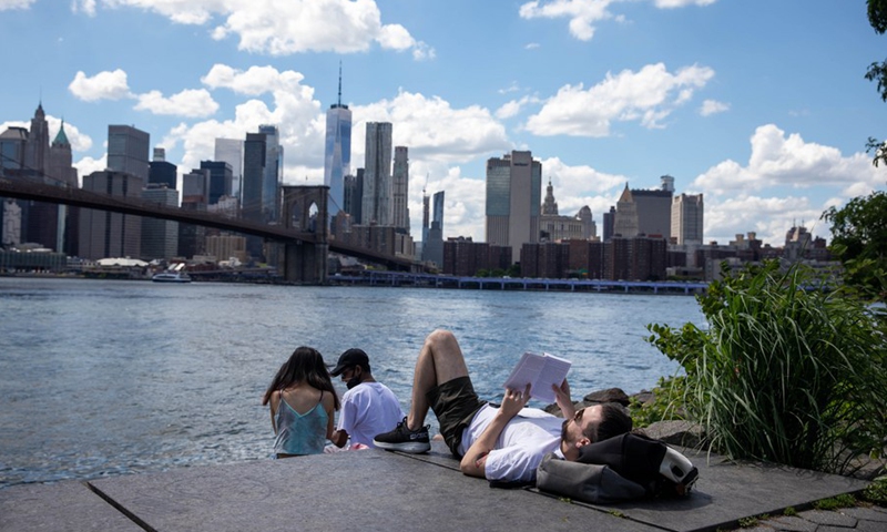 People enjoy themselves along the waterfront in the Brooklyn borough of New York, the United States, June 15, 2021. (Photo: Xinhua)