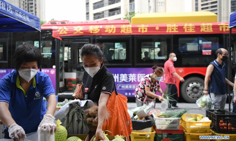Residents shop at a bus-based mobile market in Liwan District of Guangzhou, south China's Guangdong Province, June 19, 2021. Guangzhou has recently launched a bus-based mobile shopping service, which sends food and daily necessities to the city's risk areas by bus, making it easier for the citizens under epidemic control to shop at their residential areas.Photo:Xinhua