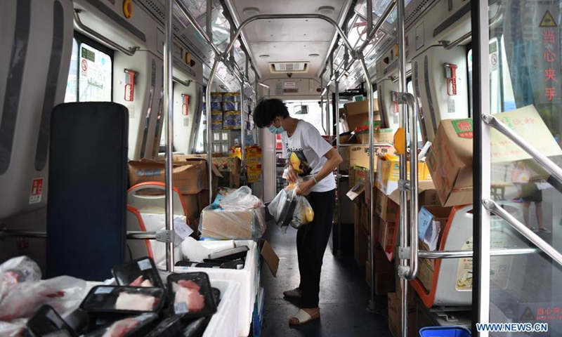 Residents shop at a bus-based mobile market in Liwan District of Guangzhou, south China's Guangdong Province, June 19, 2021. Guangzhou has recently launched a bus-based mobile shopping service, which sends food and daily necessities to the city's risk areas by bus, making it easier for the citizens under epidemic control to shop at their residential areas.Photo:Xinhua
