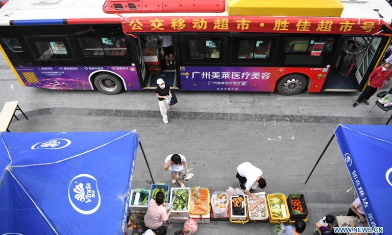 Residents shop at a bus-based mobile market in Liwan District of Guangzhou, south China's Guangdong Province, June 19, 2021. Guangzhou has recently launched a bus-based mobile shopping service, which sends food and daily necessities to the city's risk areas by bus, making it easier for the citizens under epidemic control to shop at their residential areas.Photo:Xinhua