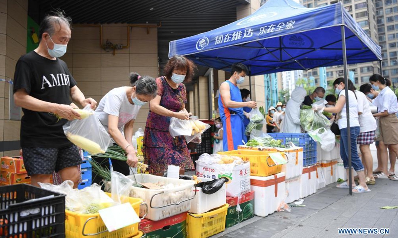 Residents shop at a bus-based mobile market in Liwan District of Guangzhou, south China's Guangdong Province, June 19, 2021. Guangzhou has recently launched a bus-based mobile shopping service, which sends food and daily necessities to the city's risk areas by bus, making it easier for the citizens under epidemic control to shop at their residential areas.Photo:Xinhua