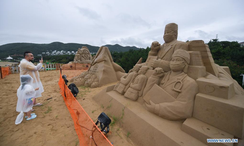 Tourists view sand creations for the upcoming 22nd Zhoushan International Sand Sculpture Festival in Zhoushan, east China's Zhejiang Province, June 19, 2021. Over 20 sand sculptors have been busy making more than 60 creations to be displayed during the 22nd Zhoushan International Sand Sculpture Festival in Zhoushan since late May. Their works are slated to be completed by late June.(Photo: Xinhua)