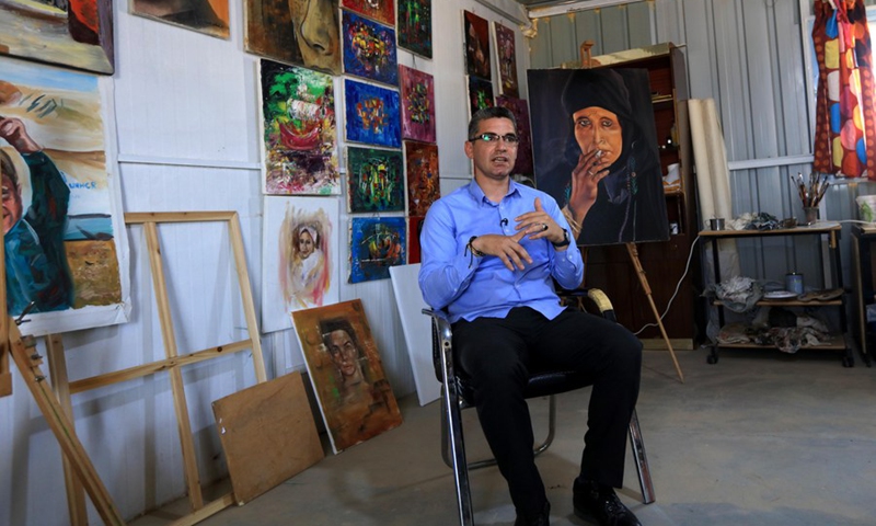 Mohamed Jokhadar speaks in his studio at the Zaatari refugee camp, Jordan, on June 17, 2021.(Photo: Xinhua)