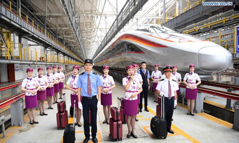 Photo taken on June 23, 2021 shows a CR400AF Fuxing intelligent bullet train and the crew members in southwest China's Chongqing. The CR400AF Fuxing intelligent bullet train will be put into service on the railway linking Chengdu, capital city of southwest China's Sichuang Province, and Chongqing on Friday.(Photo: Xinhua)