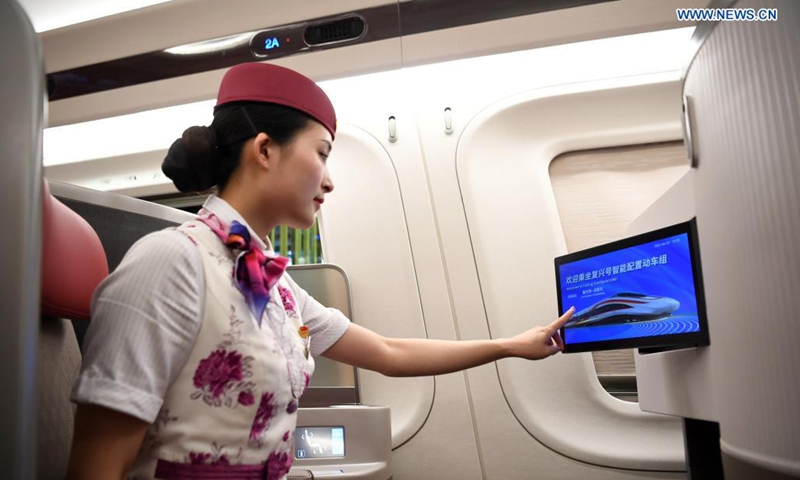 A crew member shows the function of on-board equipment on a CR400AF Fuxing intelligent bullet train in southwest China's Chongqing, June 23, 2021. The CR400AF Fuxing intelligent bullet train will be put into service on the railway linking Chengdu, capital city of southwest China's Sichuang Province, and Chongqing on Friday.(Photo: Xinhua)