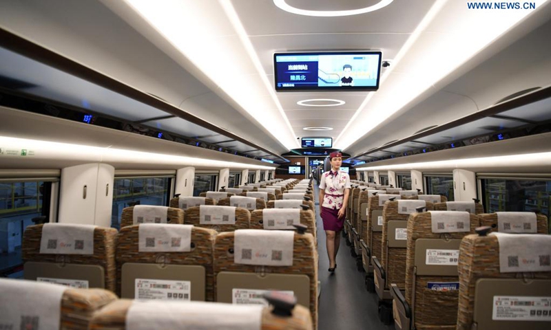 A crew member walks on a CR400AF Fuxing intelligent bullet train in southwest China's Chongqing, June 23, 2021. The CR400AF Fuxing intelligent bullet train will be put into service on the railway linking Chengdu, capital city of southwest China's Sichuang Province, and Chongqing on Friday.(Photo: Xinhua)