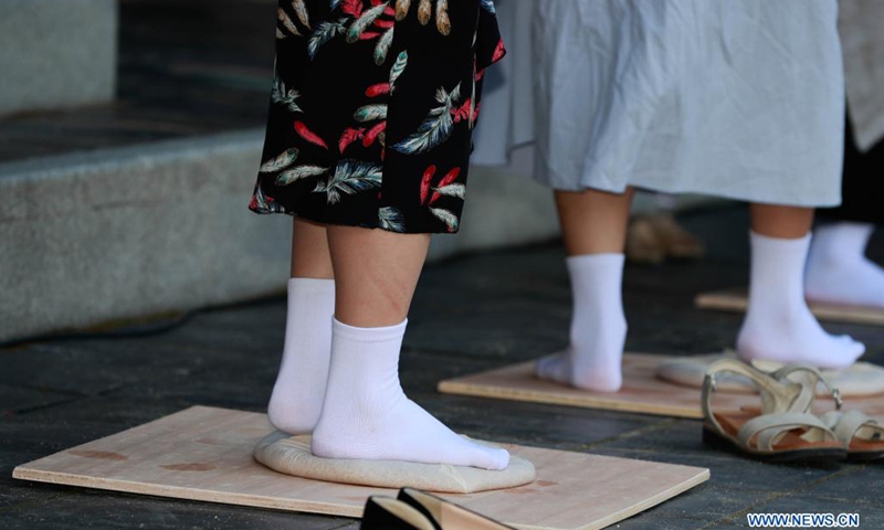 Guests experience processing nuruk, a fermentation starter used in making makgeolli, at Hwaseong Haenggung Palace in Suwon, South Korea, June 26, 2021. Makgeolli, a traditional Korean alcoholic beverage made from rice, has been listed as South Korea's national intangible cultural heritage recently.(Photo: Xinhua)
