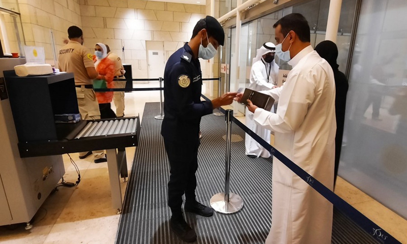 A police officer checks a visitor's civil ID and vaccination certificate at an entrance of a shopping mall in Hawalli Governorate, Kuwait, June 27, 2021.(Photo: Xinhua)