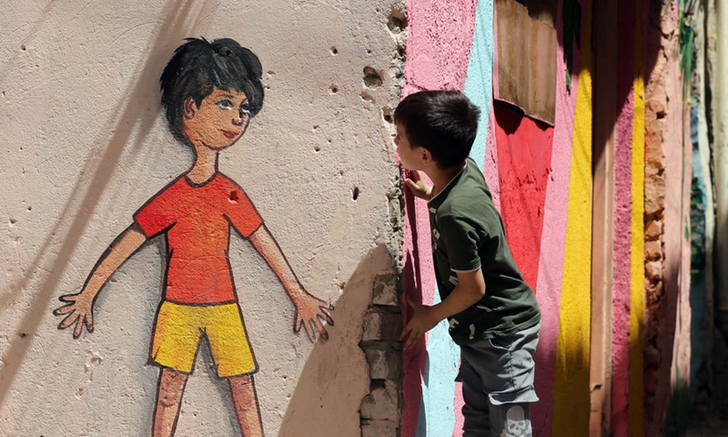 A child looks at a mural in the old al-Anbariyen slum in Baghdad, Iraq, on June 2, 2021.(Photo: Xinhua)