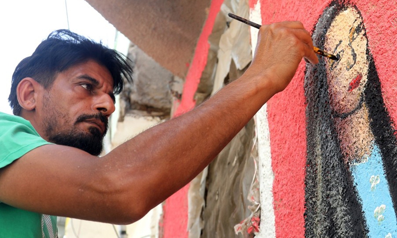 Ali Khalifa, an Iraqi painter, draws a mural on a wall in the old al-Anbariyen slum in Baghdad, Iraq, on June 2, 2021. (Photo: Xinhua)