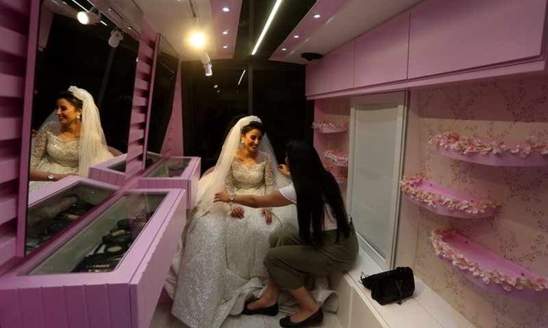 A Palestinian bride gets her makeup done inside a mobile beauty salon in the West Bank city of Nablus, on June 28, 2021.(Photo: Xinhua)