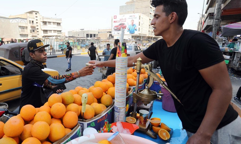 A seller hands a cup of juice to a customer in Baghdad, Iraq, on June 29, 2021. Scorching weather started here in June and temperatures rose to about 50 degrees Celsius.(Photo: Xinhua)