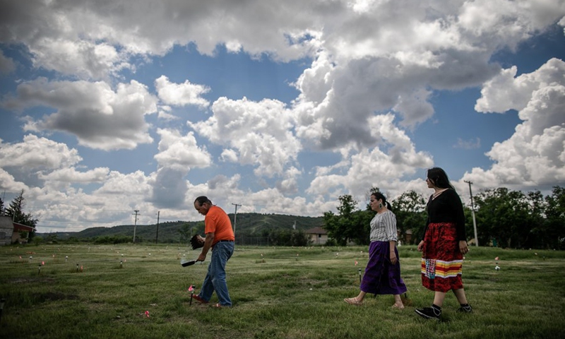 Members of the Cowessess First Nation do a ceremonial smudge at the site of unmarked graves near a former indigenous residential school in Saskatchewan, Canada, on June 27, 2021.(Photo: Xinhua)