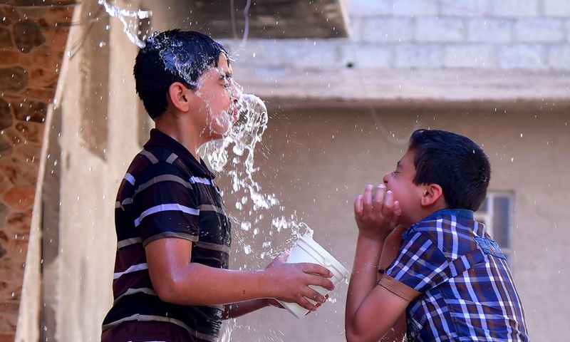 Syrian children cool off with water during hot weather in Damascus, Syria, on June 29, 2021.(Photo: Xinhua)