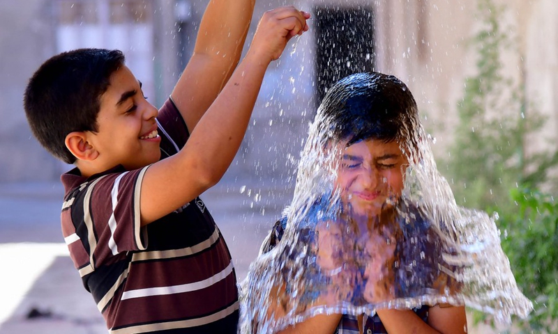 Syrian children cool off with water during hot weather in Damascus, Syria, on June 29, 2021.(Photo: Xinhua)