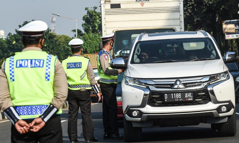 Police officers stop a woman without a face mask on her car in Jakarta, Indonesia, July 3, 2021. The Indonesian government has decided to deploy 53,000 personnel for emergency community activity restrictions (locally known as PPKM) to be imposed in Java and Bali from July 3 to 20, a senior police officer said on Friday.Photo:Xinhua