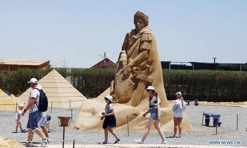 Tourists walk past a sand sculpture at the Sand City in Hurghada, Red Sea province, Egypt, on July 4, 2021.(Photo: Xinhua)