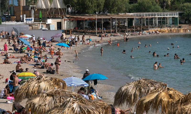 People enjoy the sun and the sea at Alimos beach, on the southern coast of Athens, Greece, June 26, 2021. City dwellers flocked to nearby beaches as Greece has been gripped by a heat wave this week.(Photo: Xinhua)