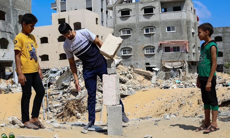 Palestinian balance artist Mohammed al-Shinbari practices balance art by using different concrete blocks picked from the rubble of war destruction, in the northern Gaza Strip town of Beit Hanoun, July 10, 2021.(Photo: Xinhua)