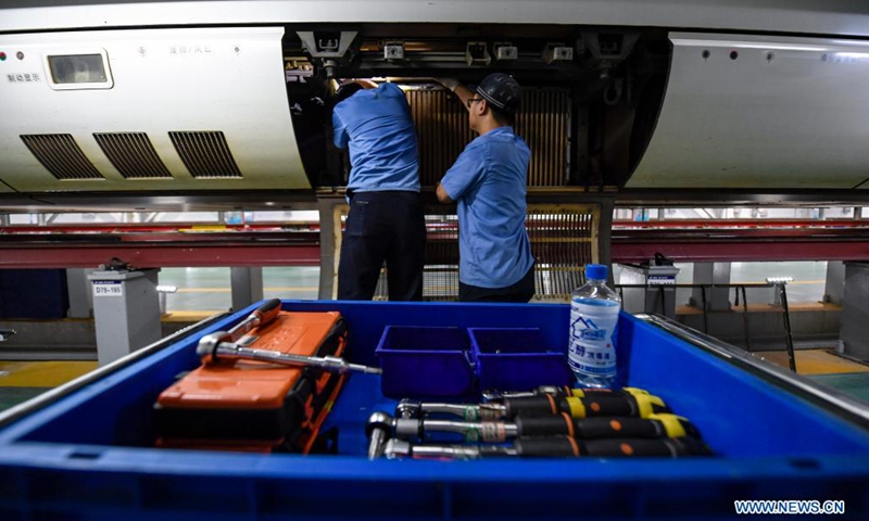 Mechanics inspect a bullet train at a maintenance base in Yinchuan, northwest China's Ningxia Hui Autonomous Region, July 10, 2021. China Railway Lanzhou Bureau Group Co., Ltd. has carried out maintenance work for trains on a daily basis to ensure train safety in the summer heat. (Photo: Xinhua)
