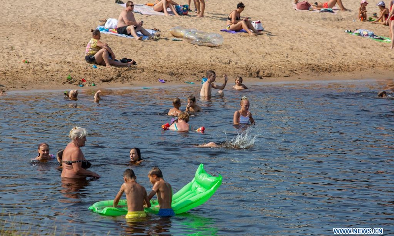People cool themselves in a river in Riga, Latvia, on July 13, 2021. The Latvian Environment, Geology and Meteorology Center has issued a red heat warning in the country, which is in effect until Friday.(Photo: Xinhua)