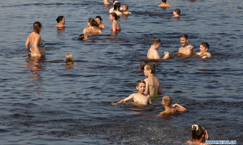 People cool themselves in a river in Riga, Latvia, on July 13, 2021. The Latvian Environment, Geology and Meteorology Center has issued a red heat warning in the country, which is in effect until Friday.(Photo: Xinhua)