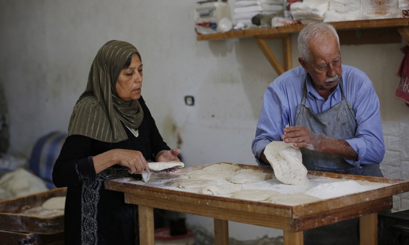 Palestinian baker Yousef Shaheen makes traditional Palestinian taboon bread at his bakery in the West Bank city of Salfit, July 13, 2021.(Photo: Xinhua)