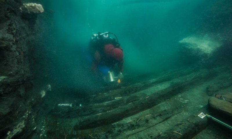 An archaeologist unearths the remains of a military vessel during an underwater archaeological mission in the coastal city of Alexandria in Egypt, on July 19, 2021. (Photo: Xinhua)
