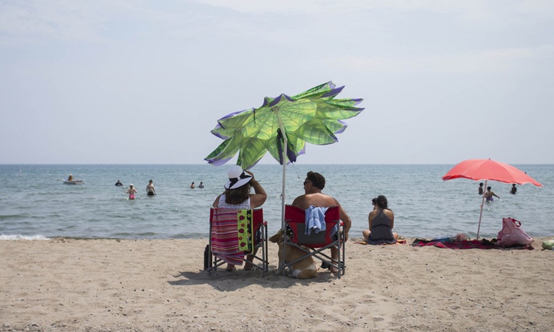 People enjoy leisure time on a beach of Lake Ontario during a heat wave in Toronto, Canada, on July 10, 2020.(Photo: Xinhua)