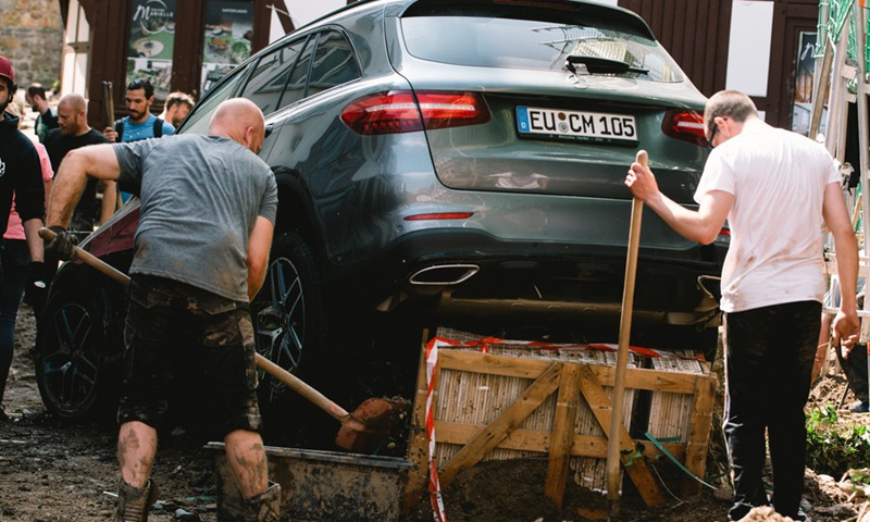 People clear a road damaged in floods in Bad Muenstereifel, western Germany, on July 17, 2021.(Photo: Xinhua)