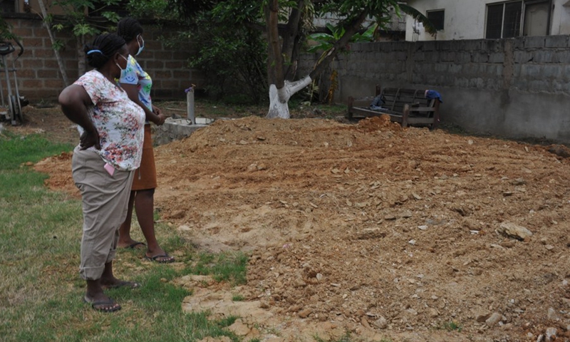 A Ghanaian mother stands with her daughter at the farm where the chickens were buried in Accra, Ghana, on July 19, 2021.(Photo: Xinhua)