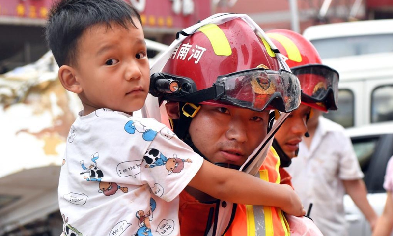 A boy is transferred to a safe place in Mihe Town of Gongyi City, central China's Henan Province, July 21, 2021. Mihe Town suffered great damage due to the heavy rainfall on July 20, with a large number of roads damaged and vehicles flooded. (Photo: Xinhua)