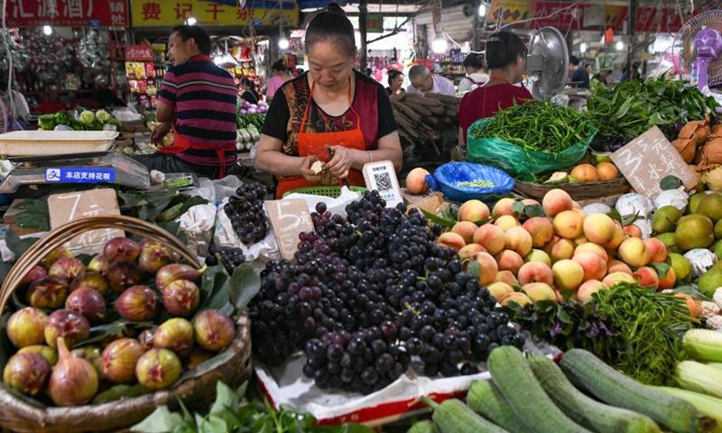 A vendor peels fruits for sale at a wet market in Chengdu, southwest China's Sichuan Province, July 20, 2021.Photo:Xinhua