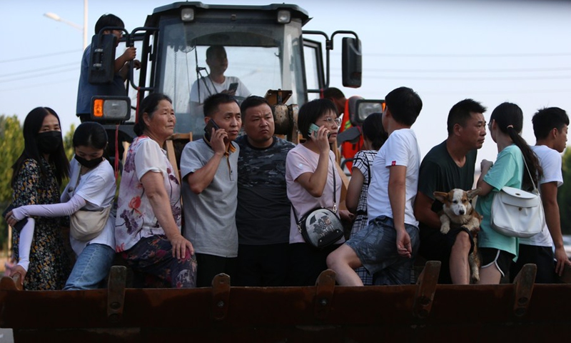 Li Wei transfers residents with a shovel loader in Baisha Town of Zhengzhou, central China's Henan Province, July 25, 2021.(Photo: Xinhua)
