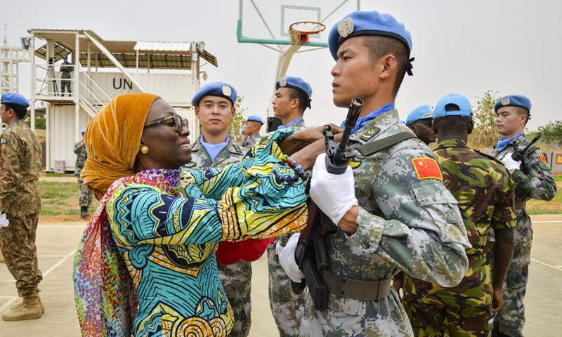 Anita Kiki Gebe, deputy joint special representative of the United Nations-African Union Mission in Darfur (UNAMID), awards UN peace medal to a soldier of the 2nd China Medium Utility Helicopter Unit (CMUHU02) in El-Fashir, Sudan, July 17, 2019. (Photo: Xinhua)