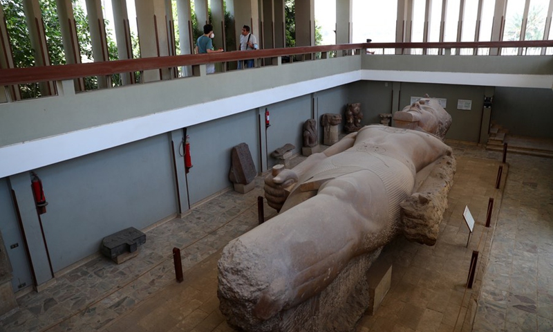 Tourists look at the lying colossal statue of ancient Egyptian Pharaoh Ramesses II at the ruins of ancient Egyptian city of Memphis, 23 km southwest of Cairo, capital of Egypt, on July 28, 2021.(Photo: Xinhua)