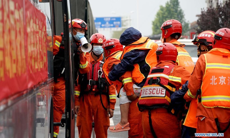 Rescuers transfer stranded people into a bus in Weihui City, central China's Henan Province, July 28, 2021. Weihui City suffered from severe urban waterlogging due to the extremely heavy rainfall. Rescue and drainage work is still in progress there.(Photo: Xinhua)