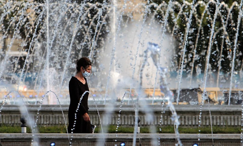 A woman walks past a fountain during a hot day in downtown Bucharest, Romania, on July 28, 2021. Romanian authorities issued an orange code, announcing a heatwave with temperatures reaching 40 degrees in the south of the Balkan country in the next few days.(Photo: Xinhua)