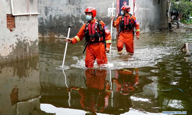 Rescuers search for stranded people while wading through waterlogged area in Weihui City, central China's Henan Province, July 28, 2021. Weihui City suffered from severe urban waterlogging due to the extremely heavy rainfall. Rescue and drainage work is still in progress there.(Photo: Xinhua)