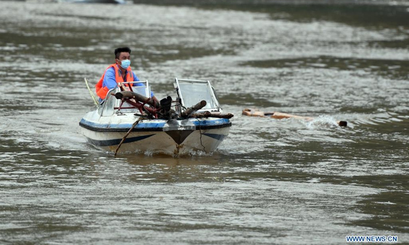 A staff member clears debris from a local reservoir in flood-hit Qixian County of Hebi City, central China's Henan Province, July 28, 2021. Several parts of Qixian County are suffering from flooding caused by heavy downpour in the past few days. (Photo: Xinhua)