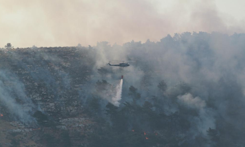 A helicopter douses wildfires in a forest in Akkar, northern Lebanon, on July 30, 2021. Lebanon battled rapidly spreading wildfires for the third day Friday in northern areas. Photo:Xinhua