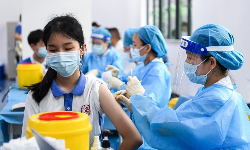 A medical worker administers a dose of COVID-19 vaccine for a student at a high school in Shenzhen, south China's Guangdong Province, July 29, 2021. The city started COVID-19 vaccination for minors aged between 12 and 17 on Thursday.Photo:Xinhua