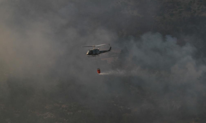 A helicopter douses wildfires in a forest in Akkar, northern Lebanon, on July 30, 2021. Lebanon battled rapidly spreading wildfires for the third day Friday in northern areas. Photo:Xinhua