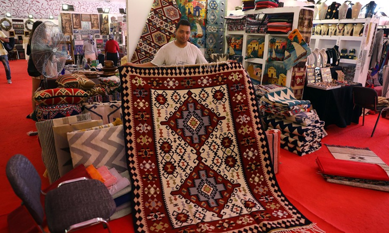 An exhibitor shows a carpet during an annual exhibition for handicrafts in the resort city of New Alamein, Matrouh province, Egypt, on July 28, 2021.(Photo: Xinhua)