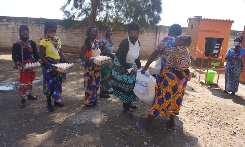 Beneficiaries of the food supplement program run by the Women's Federation for World Peace in Zambia hold received rations at a health facility in Lusaka, Zambia, on July 23, 2021.(Photo: Xinhua)